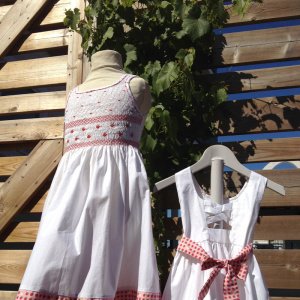 Robe en smocks blanche avec bas de robe et ceinture fraises